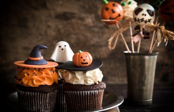 Three chocolate muffins decorated for Halloween with Halloween popsicles to the right. Blog post featured image.