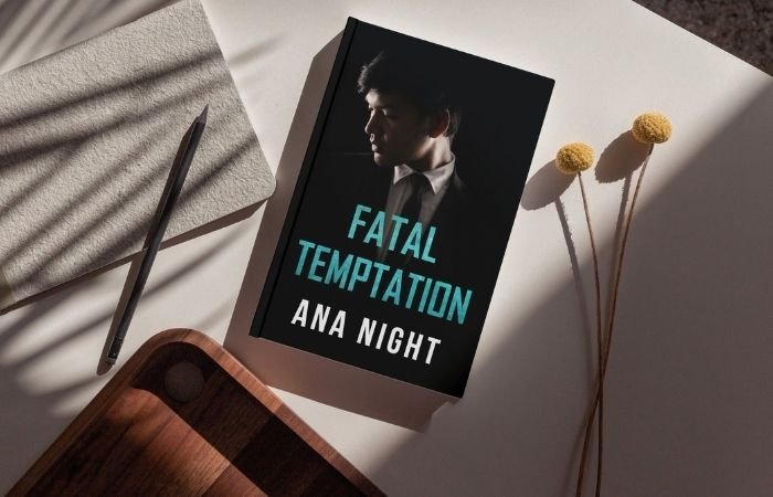 Fatal Temptation book laying on a table among scattered desk items.