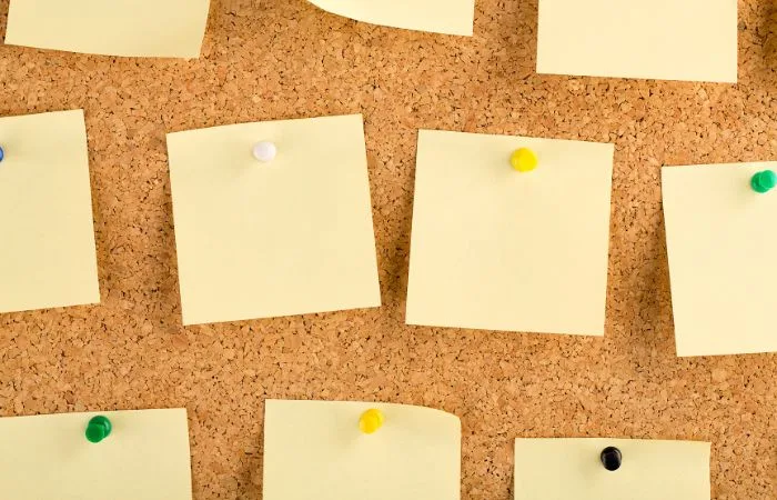 Yellow notes on a cork board. Blog post featured image.